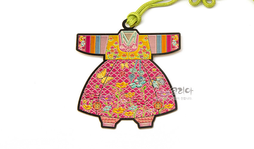 [텍스트: 샵오브코리아] 금속 재질 위 채색 기법으로 표현된 아동 색동 한복 모양 책갈피, 화려한 꽃과 나비 문양, 연두색 끈 매듭 장식 디자인