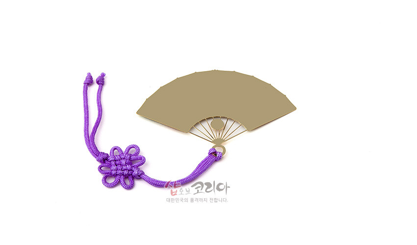 [텍스트: 샵오브코리아 대한민국의 품격까지 전합니다] 금속 재질 부채 모양 책갈피와 보라색 전통 꽃매듭 장식 조합 이미지
