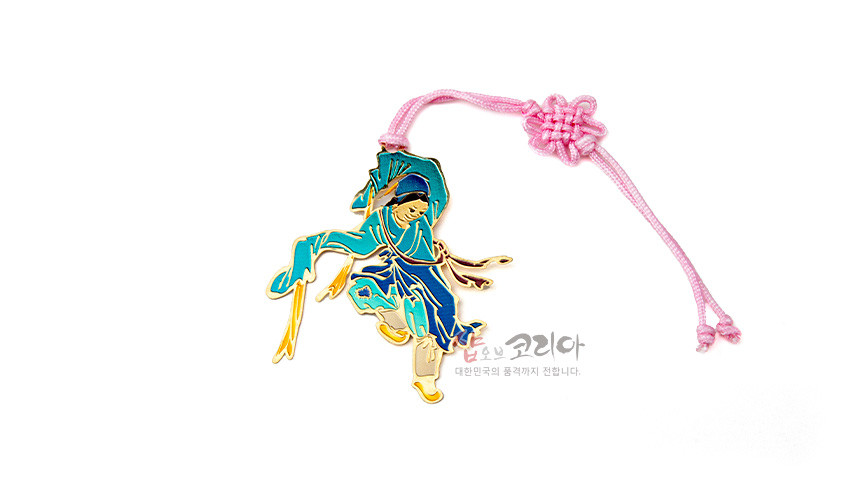 [텍스트: 샵오브코리아 대한민국의 품격까지 전합니다.] 금속 재질에 청록·남색 채색으로 조선시대 무용수 형상을 표현하고 분홍 전통 매듭 끈으로 장식한 책갈피 디자인