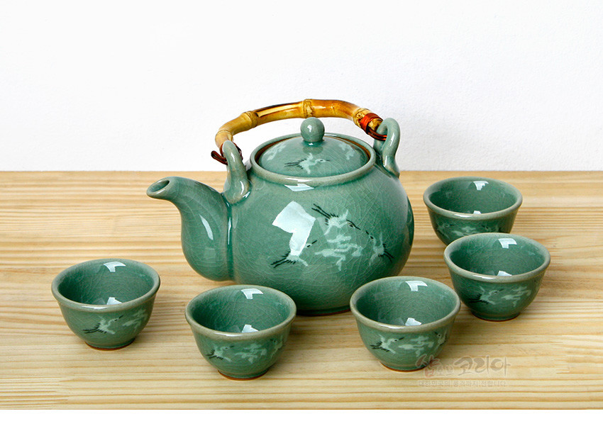 청자 재질의 녹청색 유약 위에 균열무가 퍼진 표면, 학과 구름 상감 문양이 새겨진 다관과 다섯 개의 찻잔, 대나무 손잡이 장식 구성