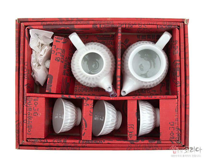 [텍스트: 샵오브코리아 대한민국의 혼까지 전합니다] 붉은 전통문양 포장 상자에 담긴 백자 재질의 흰색 빗살무늬 다관 2점과 찻잔 3점으로 구성된 3인 다기 세트 이미지