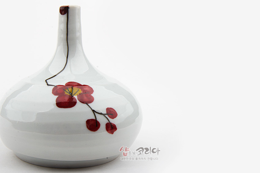 [텍스트: 샵오브코리아 대한민국의 품격까지 전합니다.] 백자 재질의 소형 화병에 수채화풍 붉은 매화와 가지 문양, 흰색 유약과 가는 목선이 조화를 이루는 도자 장식품