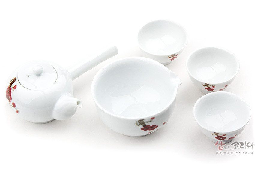 [텍스트: 샵오브코리아 대한민국의 품격까지 전합니다.] 백자 재질에 붉은 매화와 가지를 손그림 기법으로 그린 주전자·숙우·찻잔으로 구성된 3인 다기 세트 이미지 설명