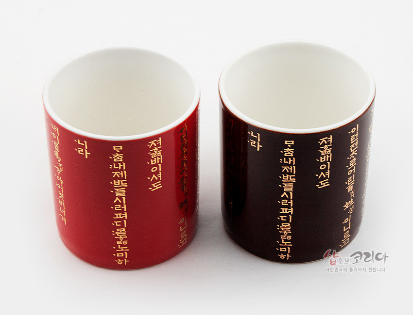 [텍스트: 나라 / 저 홀 배 이 셔 도 / 무 츰 내 제 받 든 시 러 퍼 디 물을 논 마 하 / 이 런 전 손 이 름 닐 빗 사 음 / 이는 고] 붉은색·검은색 유약 도자 표면에 금색 훈민정음 언해 글자를 세로 배치한 머그컵 한쌍 디자인