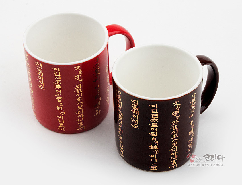 [텍스트: 나랏말싸미 듕귁에 달아 문자와로 서르 사맛디 아니할쎄] 붉은색·검은색 유약 도자 머그컵에 황금색 훈민정음 언해 세로 배열 장식 디자인
