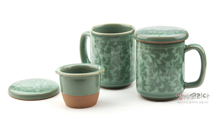 [텍스트: 샵오브코리아 대한민국의 품격까지 전합니다.] 연녹색 청자 재질에 목단당초 문양이 은은하게 상감된 머그와 거름망, 뚜껑으로 구성된 머그다기 세트 이미지 설명
