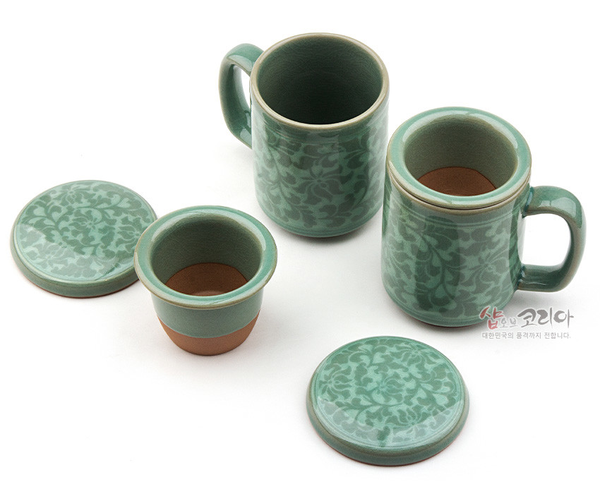[텍스트: 샵오브코리아 대한민국의 품격까지 전합니다.] 연녹색 유약의 청자 재질 위에 상감 기법으로 표현된 목단당초 문양 머그와 거름망, 뚜껑 구성의 다기 세트 이미지 설명