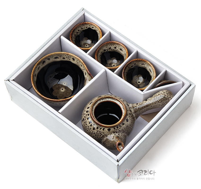 [텍스트: 샵오브코리아 대한민국의 품격까지 전합니다.] 흑유 바탕에 회갈색 호피무늬 천목 유약이 번진 도자 재질의 다관, 숙우, 찻잔 3점 구성 다기 세트 모습