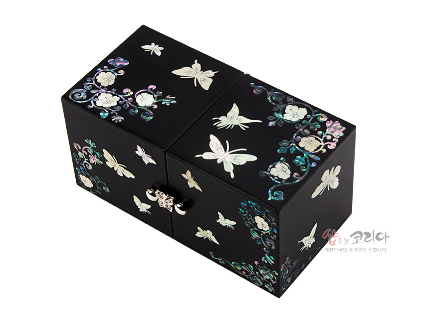 [텍스트: 샵오브코리아 대한민국의 품격까지 전달합니다.] 무광 흑색 옻칠 위에 자개 상감으로 표현된 나비와 꽃 문양, 전면 금속 장식 손잡이가 돋보이는 직사각 쌍합 형태 수납함 이미지 설명