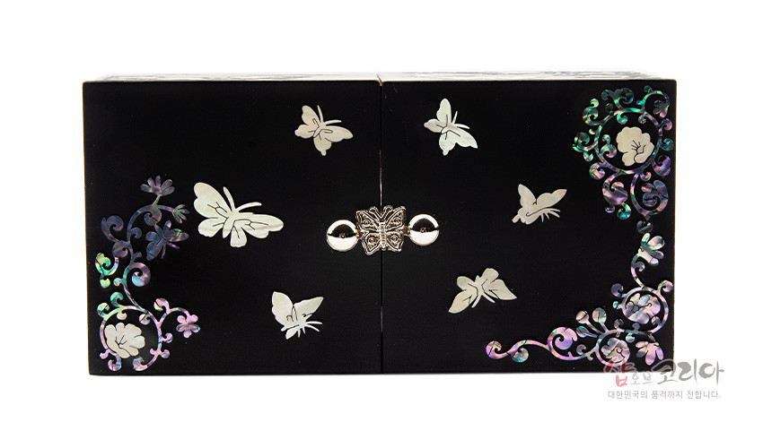 [텍스트: 샵오브코리아 대한민국의 품격까지 전합니다] 검은 옻칠 바탕 위 나비와 꽃 자개 상감 문양, 중앙 은빛 금속 잠금장식이 조화를 이루는 직사각 쌍합 디자인