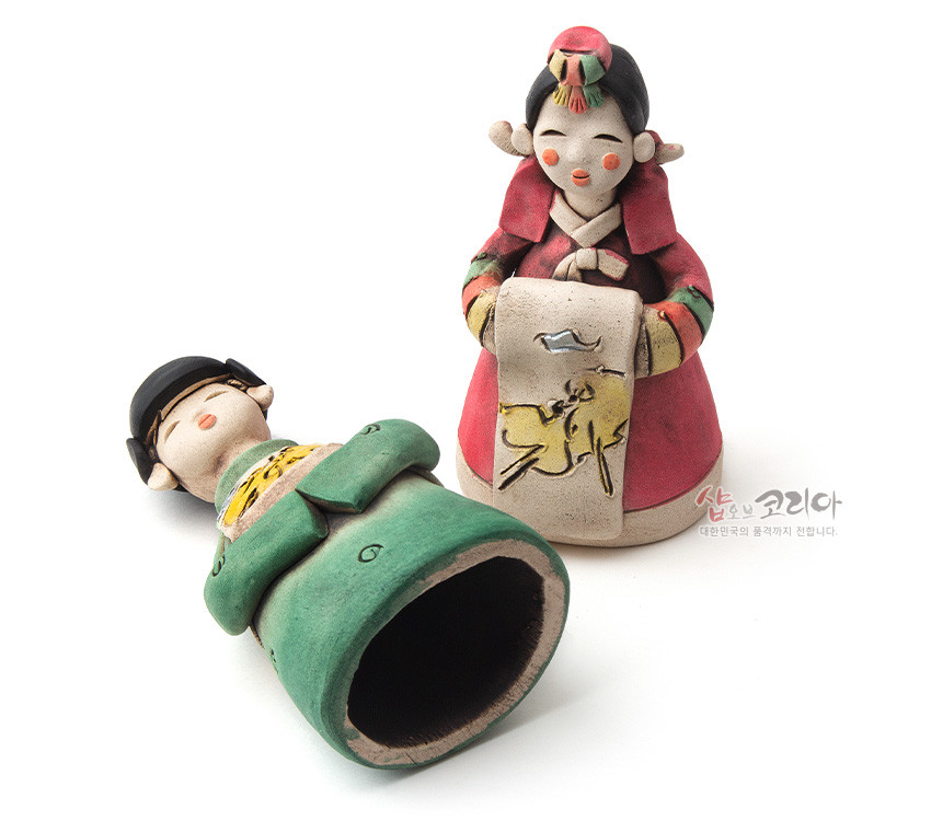 [텍스트: 샵오브코리아 대한민국의 품격까지 전합니다.] 황토를 빚어 구운 도자 재질 신랑신부 인형, 녹색·홍색 한복 채색과 가슴 패널의 노랑 동물 문양·수묵화 풍 장식이 특징인 전통 혼례 인형 구성
