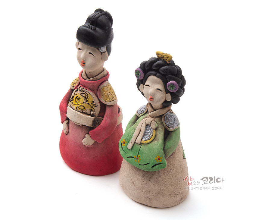 [텍스트: 샵오브코리아 대한민국의 품격까지 전합니다] 황토를 빚어 저온 소성한 도자 인형, 붉은 곤룡포의 용문양과 녹색 한복에 꽃자수 문양을 채색한 왕과 왕비 형상 장식