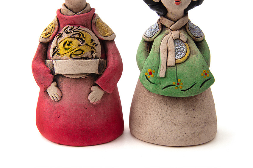 무지 황토를 빚어 구워낸 도자 인형, 붉은 곤룡포의 황색 용문과 어깨 장식, 녹색 저고리 위 은색 견장과 꽃무늬 장식을 채색한 왕과 왕비 형상