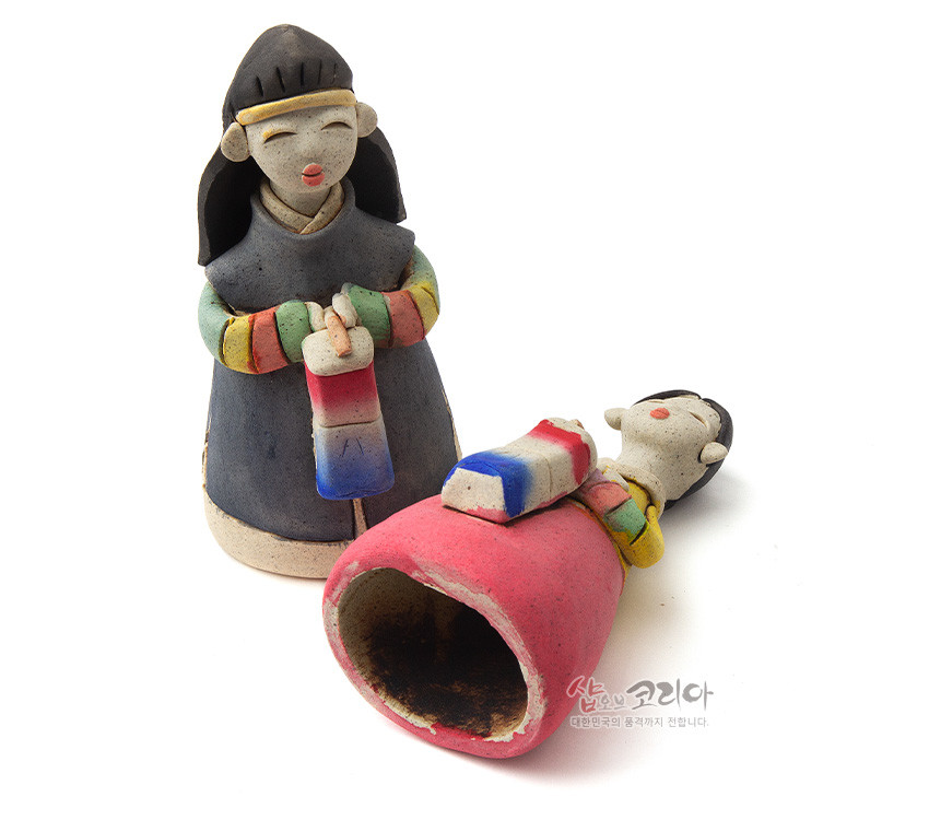 [텍스트: 샵오브코리아 대한민국의 품격까지 전합니다.] 거친 황토 질감의 도자 재질로 빚은 남녀 한복 인형과 붉은·파란 삼색 청사초롱, 색동 저고리 소매와 단순화된 조형미가 돋보이는 전통 공예 인형 구성