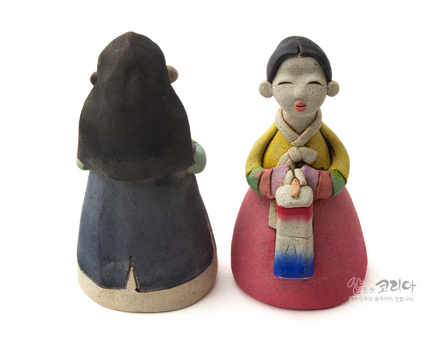 [텍스트: 샵오브코리아 대한민국의 품격까지 전달합니다.] 황토 질감 도자 재질의 남녀 한복 인형, 색동 소매와 분홍치마·남색 도포 대비, 붉은·파랑 그라데이션 청사초롱 장식이 돋보이는 전통 조형미 표현 인형