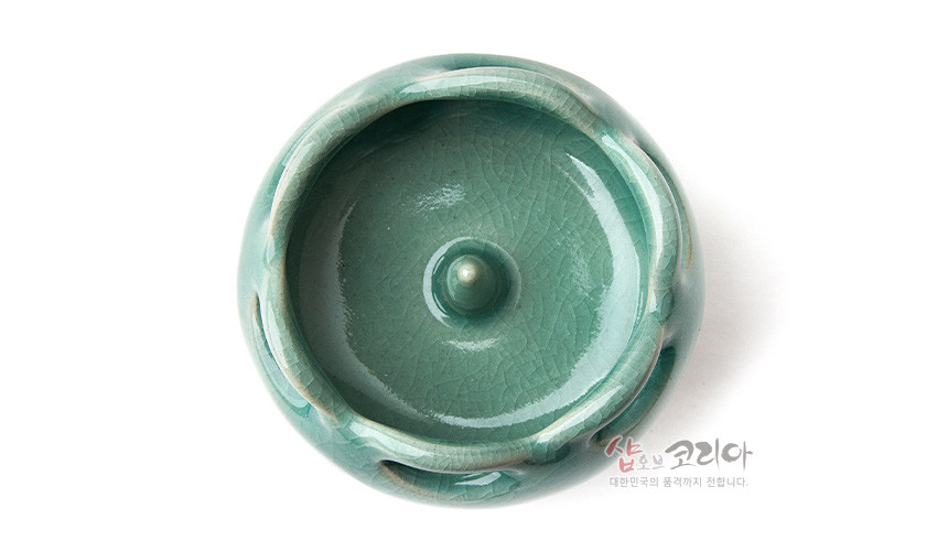 [텍스트: 샵오브코리아 대한민국의 멋, 그대로 전합니다.] 비색 청자유와 은은한 크랙 기법이 더해진 원형 촛대 상부, 가장자리 완만한 곡선과 중앙 돌기 장식 특징