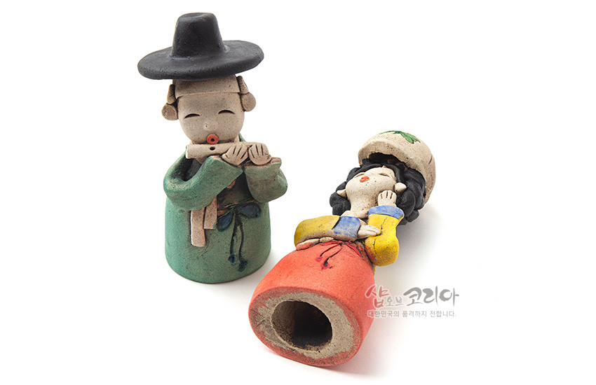 [텍스트: 샵오브코리아 대한민국의 품격까지 전합니다.] 황토 재질 손조각 기법의 선비와 여인 인형, 녹색 도포와 검은 갓, 노랑 저고리와 붉은 치마의 채색 대비가 돋보이는 전통 복식 조형 인형