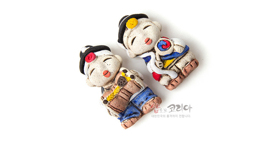 [텍스트: 샵오브코리아 대한민국의 품격까지 전합니다.] 황토 질감 도자 재질 위에 농악 의상과 태극 문양을 수채색처럼 채색한 인형 형태 냉장고 자석, 붉은·파랑·노랑 대비 색채와 전통 악기 장식 표현
