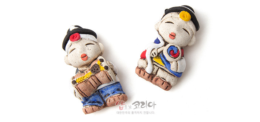 [텍스트: 샵오브코리아 대한민국의 품격까지 전합니다.] 황토 느낌 거친 질감 도자 재질 농악 인형 냉장고 자석, 태극 문양과 붉은·파란·노란 색상 포인트, 전통 악기 장식 표현