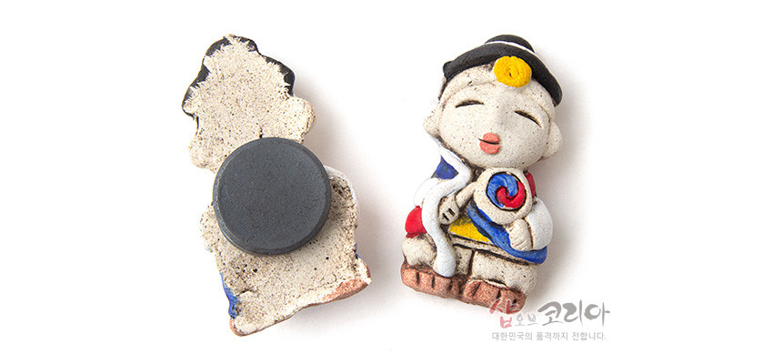 [텍스트: 샵오브코리아 대한민국의 품격까지 전합니다.] 거친 황토 질감의 도자 재질 농악 인형 냉장고 자석, 태극 문양 북과 삼원색 한복 장식 특징의 소품