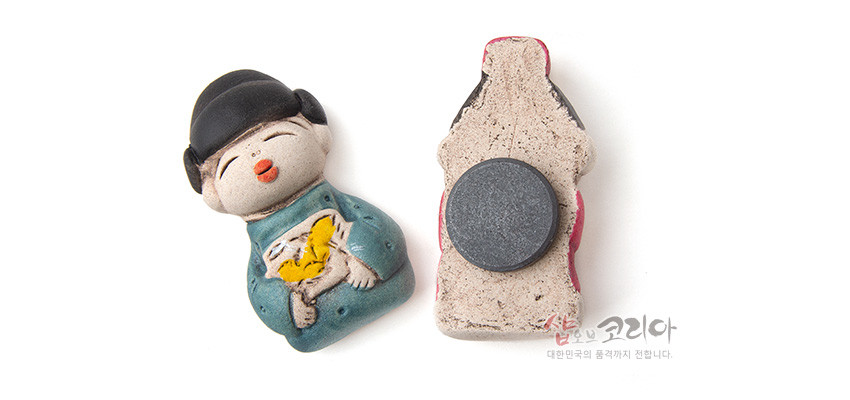 [텍스트: 샵오브코리아 대한민국의 품격까지 전합니다.] 황토 느낌 도자 재질의 신랑신부 형상 냉장고 자석, 청록색 한복 위 노란 나비 문양과 뒷면 원형 자석 부착 디자인