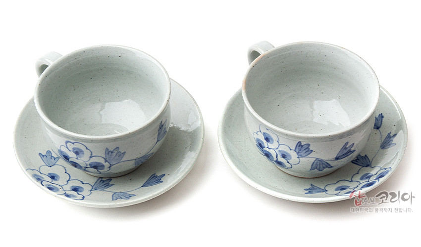 [텍스트: 샵오브코리아 대한민국의 품격까지 전합니다.] 회백색 분청 도자기에 수묵화풍 청색 목단문양이 그려진 2인용 커피잔과 받침 구성