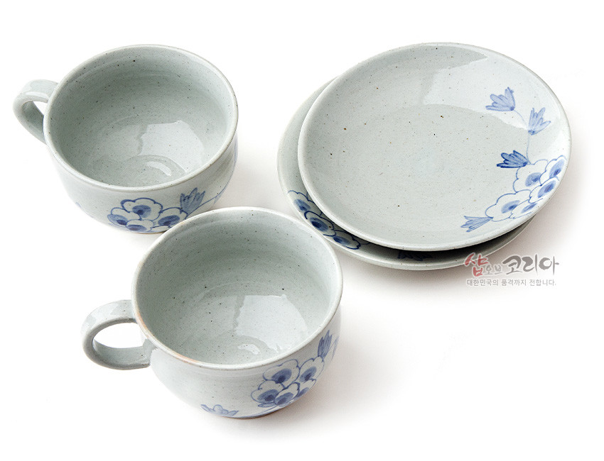 [텍스트: 샵오브코리아 대한민국의 품격까지 전합니다.] 흐린 회백색 분청 도자 위 청색 목단문 수묵화풍으로 장식된 커피잔과 받침 2인 세트 구성