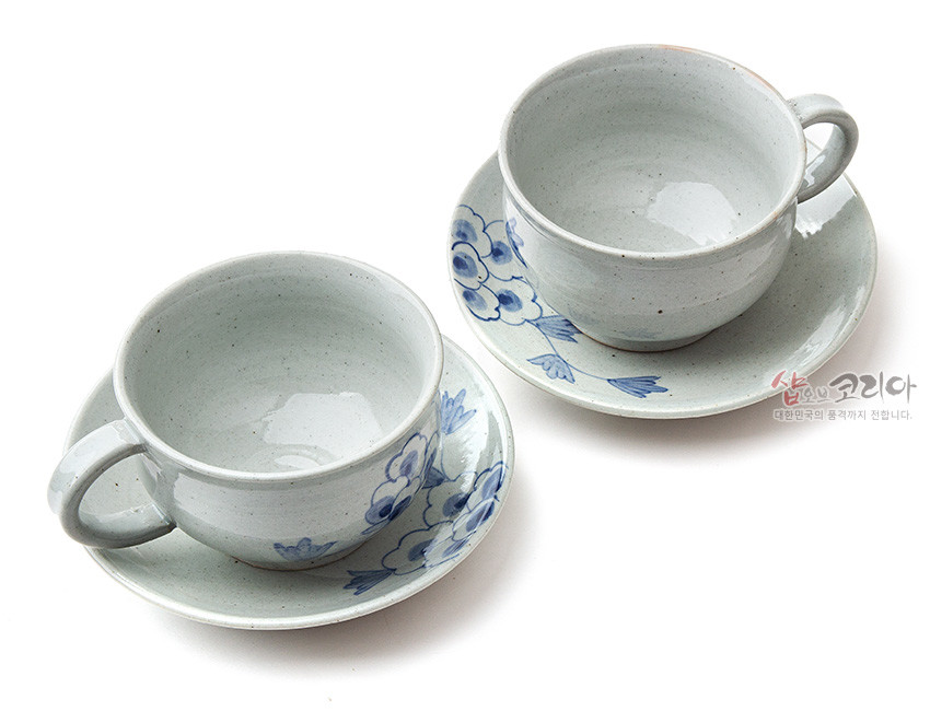 [텍스트: 샵오브코리아 대한민국의 멋과 정까지 전합니다.] 회백색 분청 도자에 청색 목단 문양이 수묵화풍으로 장식된 2인용 커피잔과 받침 구성