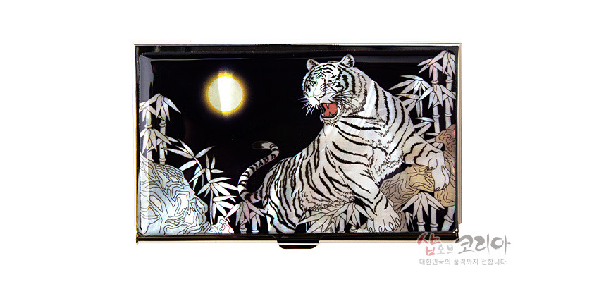 [텍스트: 샵오브코리아 대한민국의 품격까지 전합니다.] 흑색 바탕 금속 명함케이스에 자개 상감 기법으로 백호와 대나무, 둥근 달 문양을 섬세하게 표현한 디자인