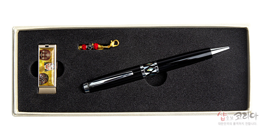 [텍스트: 샵오브코리아 대한민국의 품격까지 전합니다.] 검은 옻칠 자개 상감 기하 문양 볼펜과 금속 바디에 다채로운 한국 탈 문양을 인쇄한 USB, 붉은 색실 매듭 장식이 함께 놓인 세트 구성 이미지