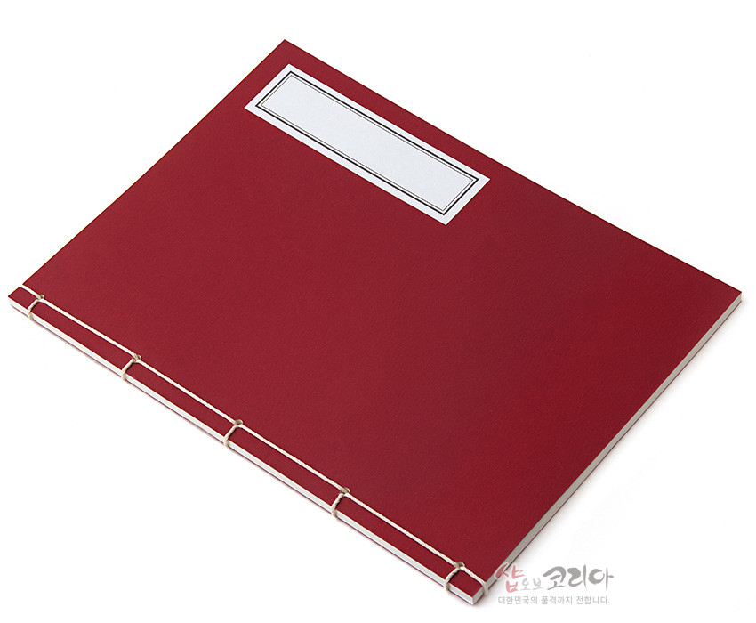 [텍스트: 샵오브코리아 대한민국의 품격까지 전합니다.] 짙은 적색 종이 표지에 흰색 실로 엮은 전통 오침 제본과 흰색 직사각 라벨이 조화를 이루는 수공예 노트 디자인