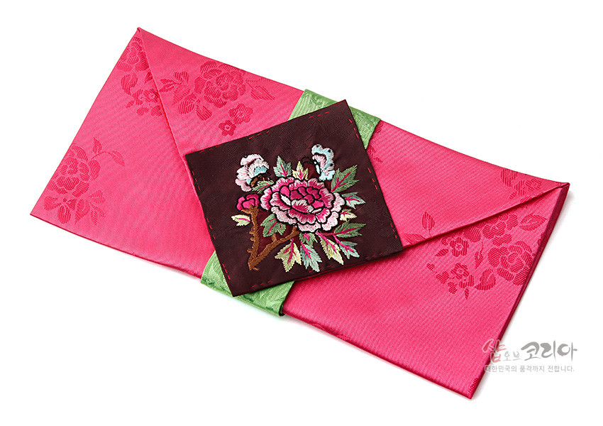 [텍스트: 샵오브코리아 대한민국의 품격까지 전합니다.] 분홍 비단 바탕에 장미 문양 양각 직조, 중앙 자주색 비단에 화려한 모란과 잎사귀 자수, 연두색 비단 단으로 포인트를 준 봉투형 예단보 디자인