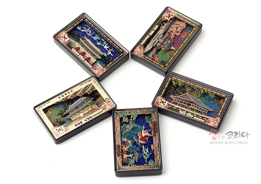 [텍스트: KOREA, 샵오브코리아 대한민국의 품격까지 전달합니다.] 자개 느낌 바탕 위 궁궐과 연못, 벚꽃과 학, 잉어 등을 입체 부조 금속 테두리와 오방색 계열로 장식한 직사각형 마그넷 구성