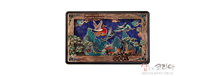 [텍스트: The symbol of longevity, 십장생도] 금속 재질 입체 부조 기법, 청록과 남색 배경 위 산수·해·구름·학·사슴·거북 등 십장생도 문양이 섬세하게 표현된 직사각형 마그넷 디자인