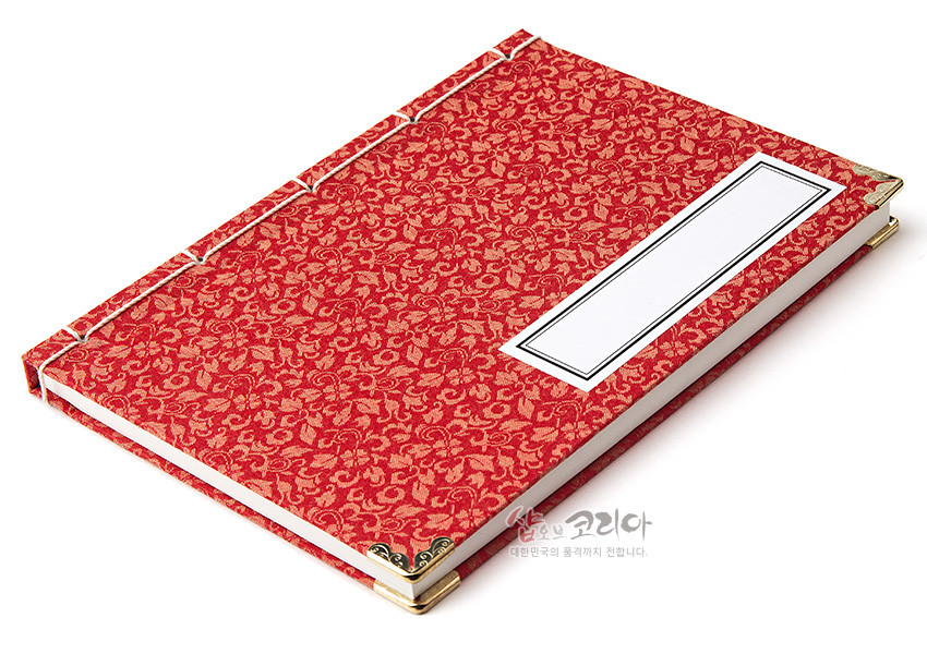 [텍스트: 샵오브코리아 대한민국의 품격까지 전합니다.] 적색 비단 위 금색 전통 문양 직조 표지와 금속 모서리 장식, 흰 실로 엮은 오침 제본, 직사각형 제목지 디자인 노트