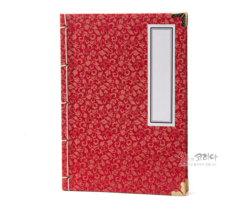 [텍스트: 샵오브코리아 전통의 품격까지 전합니다.] 붉은 비단에 금색 꽃문양 직조된 표지와 금속 모서리 장식, 가는 실로 엮은 전통 오침 제본 구조의 노트 모습