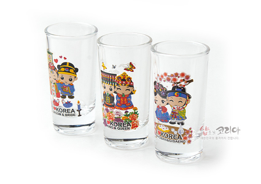 [텍스트: KOREA GROOM & BRIDE / KOREA KING & QUEEN / KOREA YANGBAN & GISAENG] 투명 유리잔에 한복 입은 커플 캐릭터와 꽃, 나비, 버드나무 등 다채로운 색상의 전통 문양을 인쇄한 3종 양주잔 세트 이미지 설명