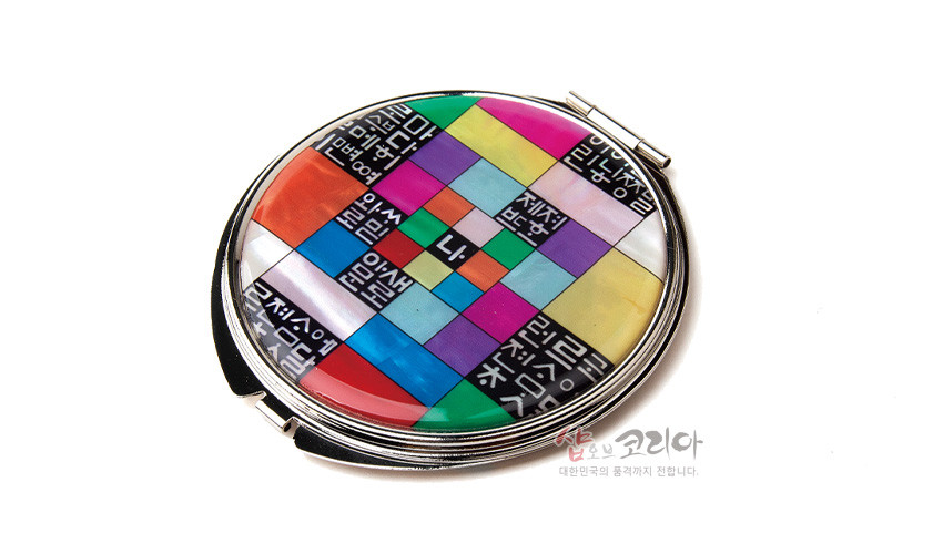 [텍스트: 나, 세종, 훈민정음] 자개 상감과 옻칠 기법의 금속 손거울, 오방색 조각보 배경 위 흑백 훈민정음 문자 문양 구성