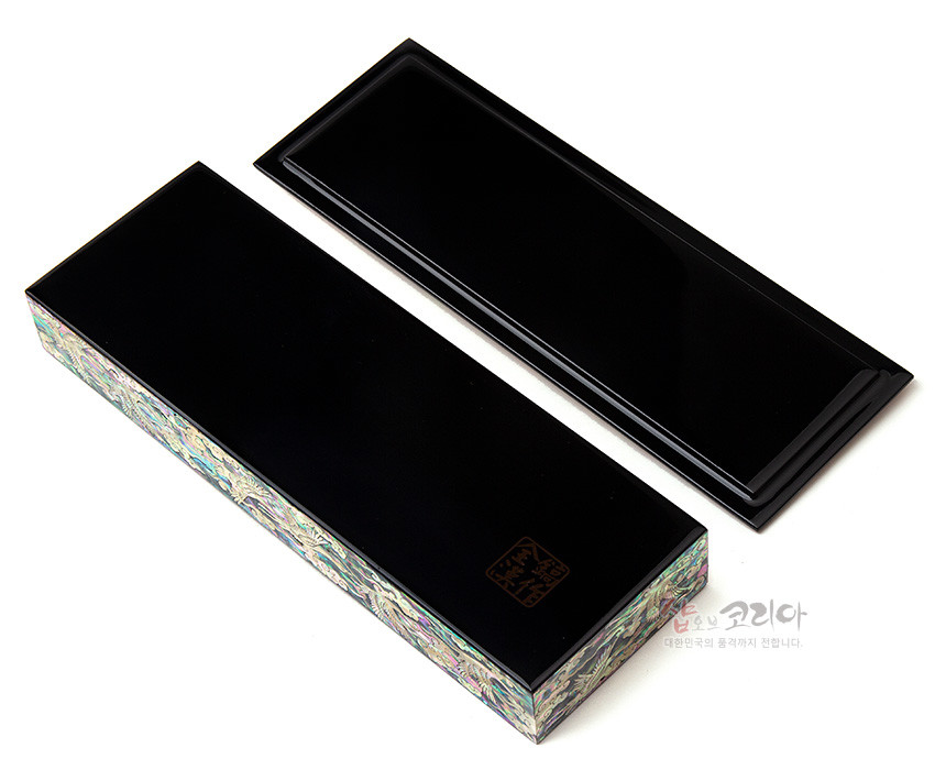 [텍스트: 샵오브코리아 대한민국의 혼과 멋을 전합니다.] 흑색 옻칠 바탕에 측면 자개 상감으로 빛나는 문양을 두른 직사각 필함과 명함케이스 세트 모습