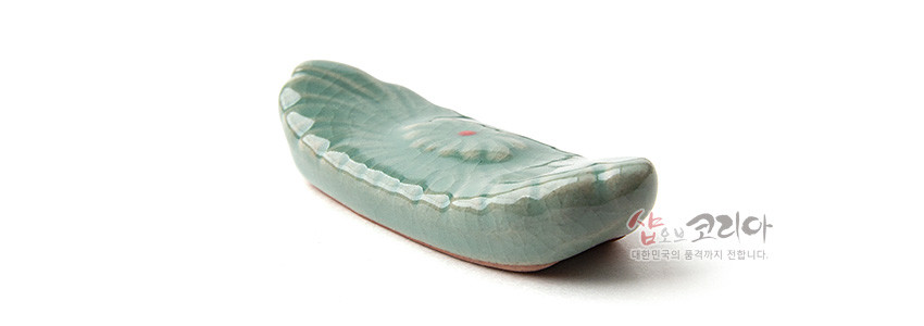 [텍스트: 샵오브코리아 대한민국의 품격까지 전합니다.] 연녹색 청자 재질에 비취색 유약을 입힌 수저받침, 음각 꽃무늬와 붉은 점 포인트가 돋보이는 곡선형 디자인
