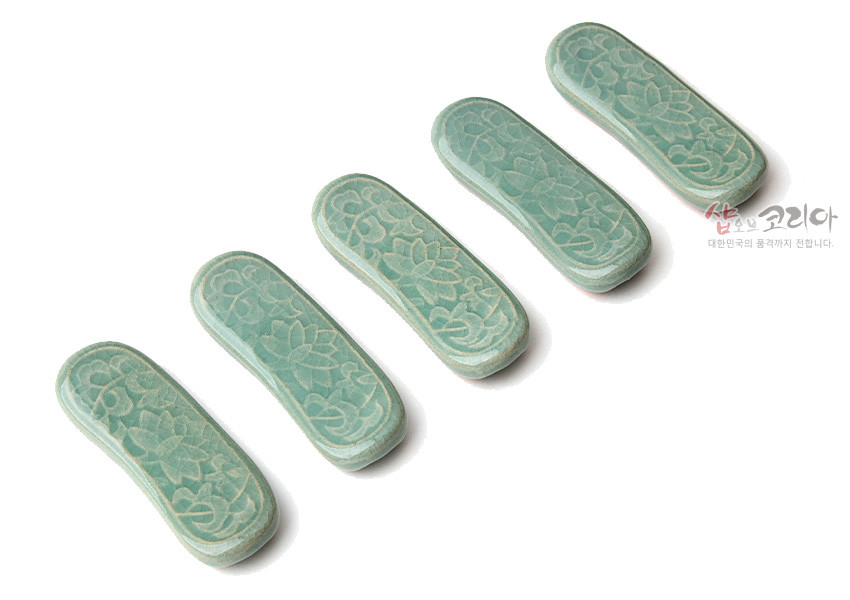 [텍스트: 샵오브코리아 대한민국의 품격까지 전합니다.] 비취색 청자 재질에 연꽃과 당초무늬를 음각으로 새긴 곡선형 수저받침 5종 세트 이미지