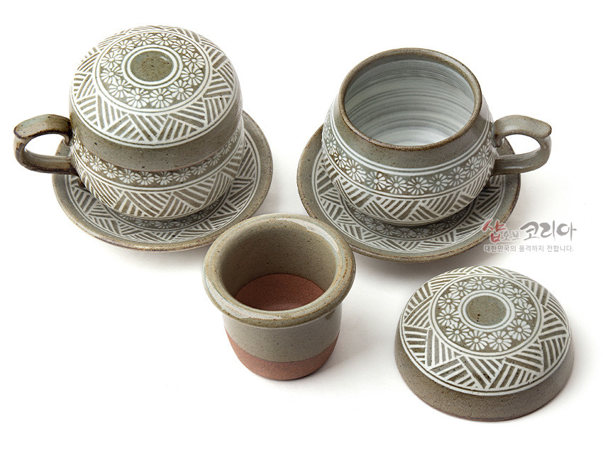 [텍스트: 샵오브코리아 대한민국의 품격까지 전합니다.] 분청사기 재질의 2인 다기잔 세트, 백색 상감 기법으로 국화문과 기하학 문양을 둘러 장식한 회갈색과 백색 대비의 뚜껑잔과 받침 구성