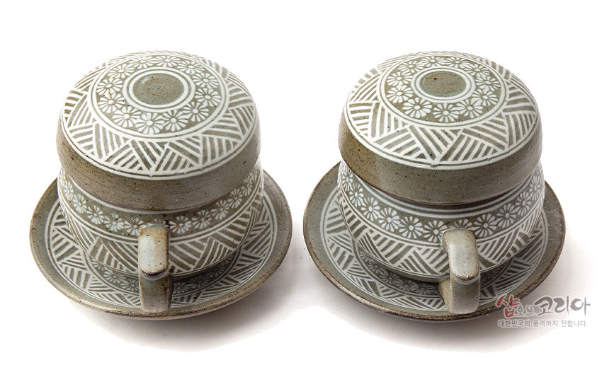 [텍스트: 샵오브코리아 대한민국의 품격까지 전합니다.] 분청사기 재질의 다기잔과 받침 세트, 백색 상감 기법으로 국화문과 기하학 문양을 촘촘히 둘러 장식한 2인 다기잔 구성