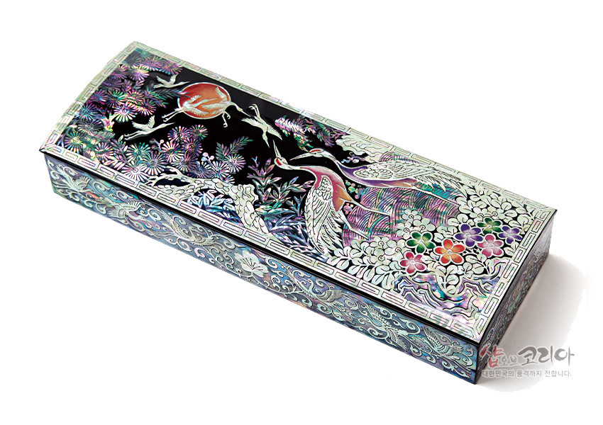 [텍스트: 샵오브코리아 대한민국의 품격까지 전합니다] 흑칠 바탕 위 자개 상감 기법으로 송학, 소나무, 구름, 국화와 화문을 표현한 둥근 필함, 오색 진주광과 연속 문양 장식 디자인