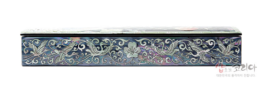 [텍스트: 샵오브코리아 대한민국의 품격까지 전합니다.] 자개 상감 기법으로 측면을 장식한 옻칠 필함, 오색 자개 바탕에 송학과 꽃, 운문이 연속된 문양 구성