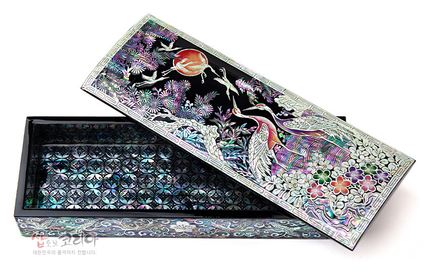 [텍스트: 샵오브코리아 대한민국의 품격까지 전합니다] 흑색 옻칠 바탕 위 자개 상감 기법으로 송학·소나무·구름·국화 문양을 화려한 오색 광택으로 표현한 직사각형 필함 내부 자개 기하학 무늬 장식 이미지 설명