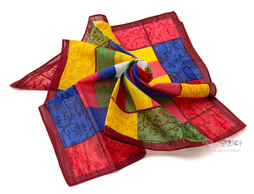 [텍스트: 샵오브코리아 대한민국의 품격까지 전합니다.] 반투명 비단 느낌 소재에 붉은 테두리와 노랑·파랑·초록·빨강 색동 조각보 패턴, 꽃·덩굴 문양이 직조된 전통 손수건 디자인