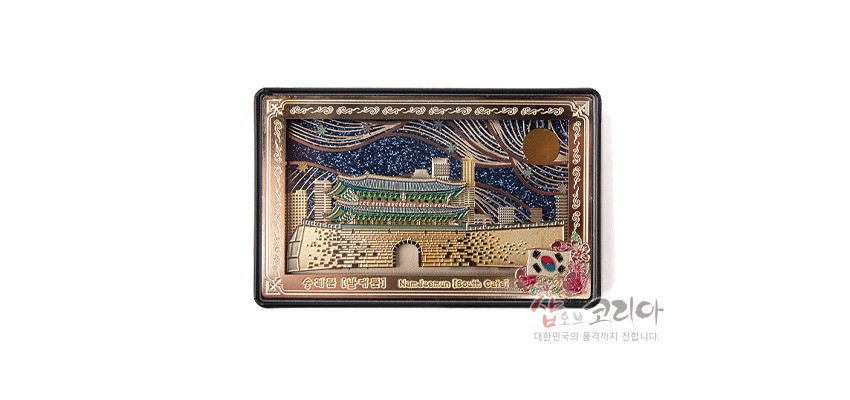 [텍스트: 숭례문 (남대문) Namdaemun (South Gate)] 금속 재질 입체 부조 기법으로 표현된 숭례문 전경과 남색 밤하늘 배경, 금색·초록색 대비, 태극기 장식 포인트 디자인