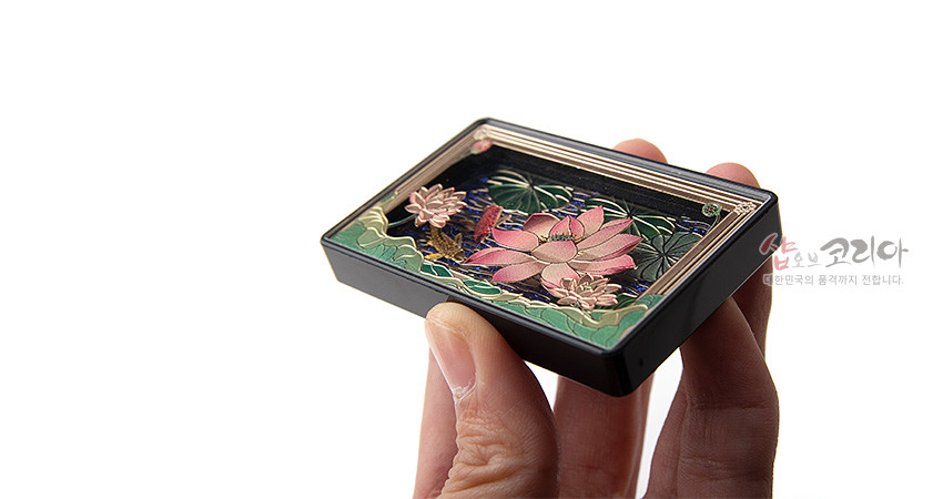 [텍스트: 샵오브코리아 대한민국의 품격까지 전합니다.] 금속 위에 분홍 연꽃과 연잎을 입체 양각하고 청록·남색 수면 배경과 금빛 테두리로 장식한 직사각형 냉장고 자석형 마그넷 디자인