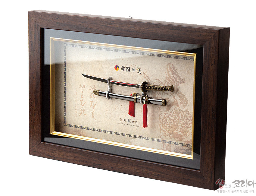 [텍스트: 韓國의美, 이순신장검, LEE SOON-SHIN’s long-sword] 짙은 원목 액자 속 금속 장검과 칼집, 붉은 술 장식, 전통 문양 배경지와 금색 라인 테두리가 어우러진 입체 장식 액자형 구성